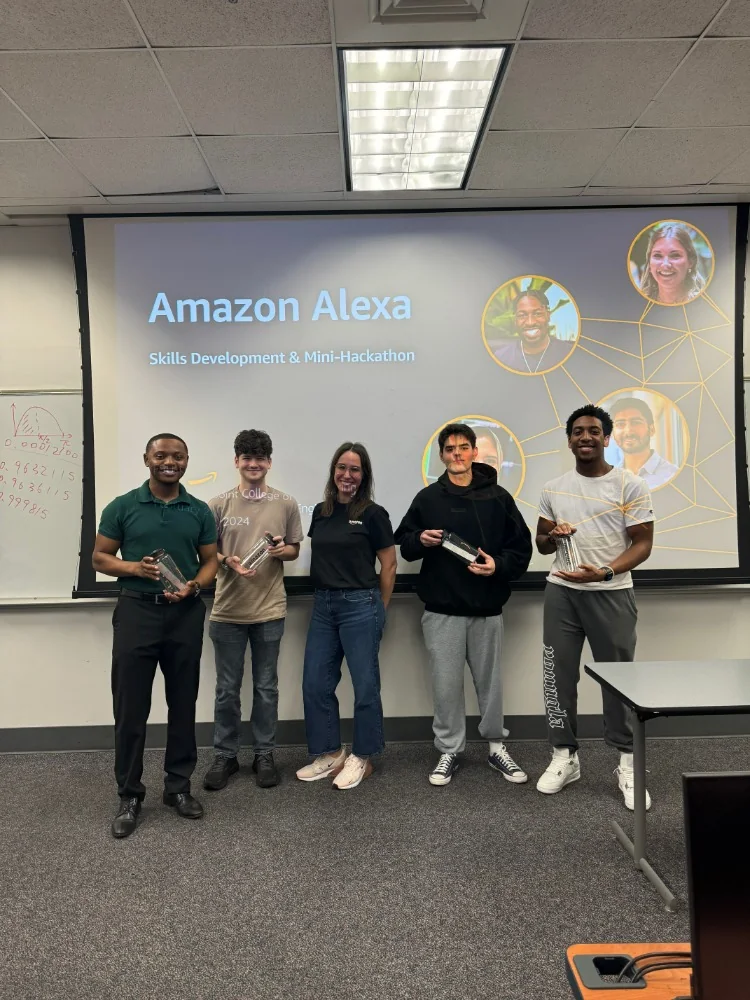 Five hackathon participants holding awards in front of a slide reading Amazon Alexa Skills Development and Mini-Hackathon
